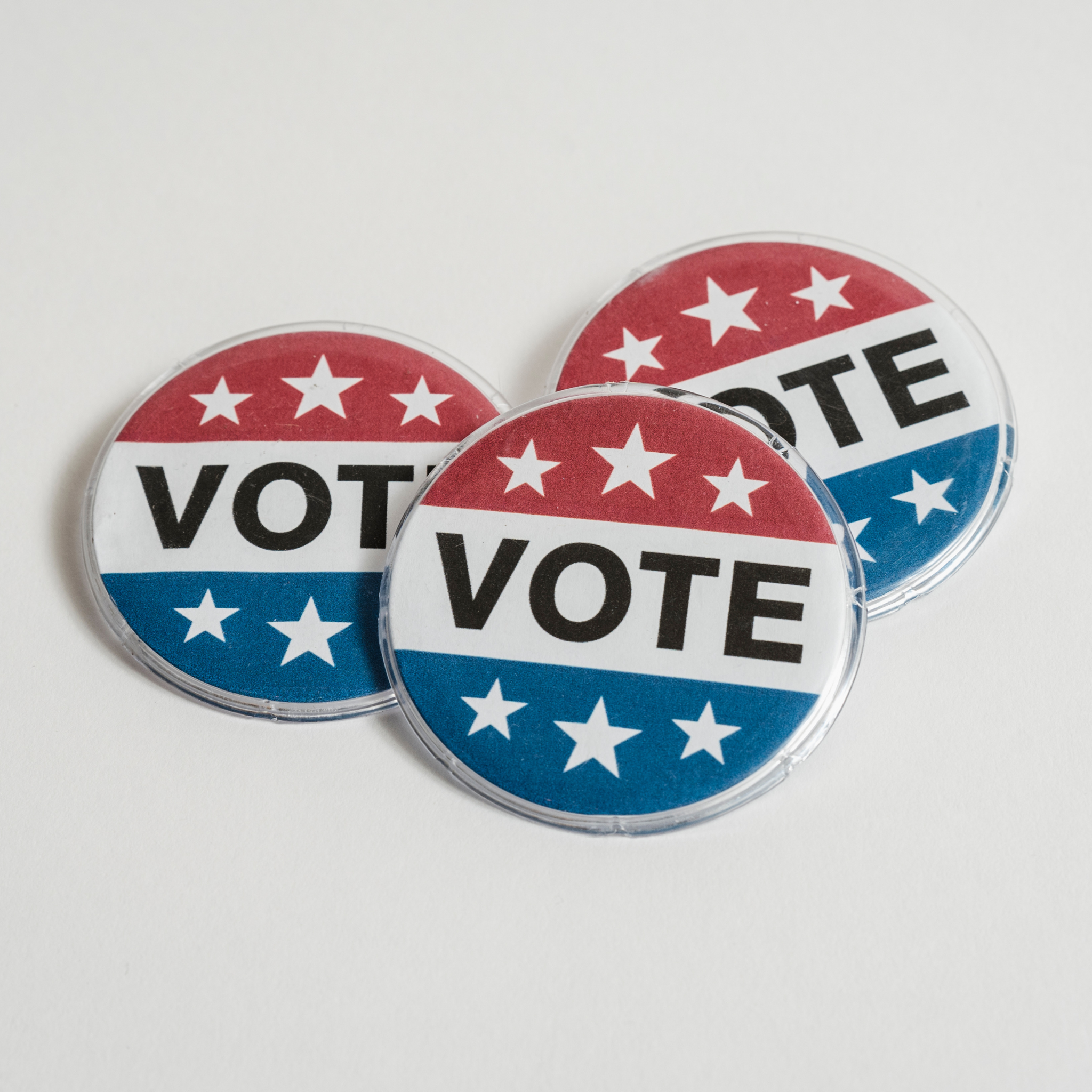 Photo of three 'I Voted' stickers on a light grey background. 
